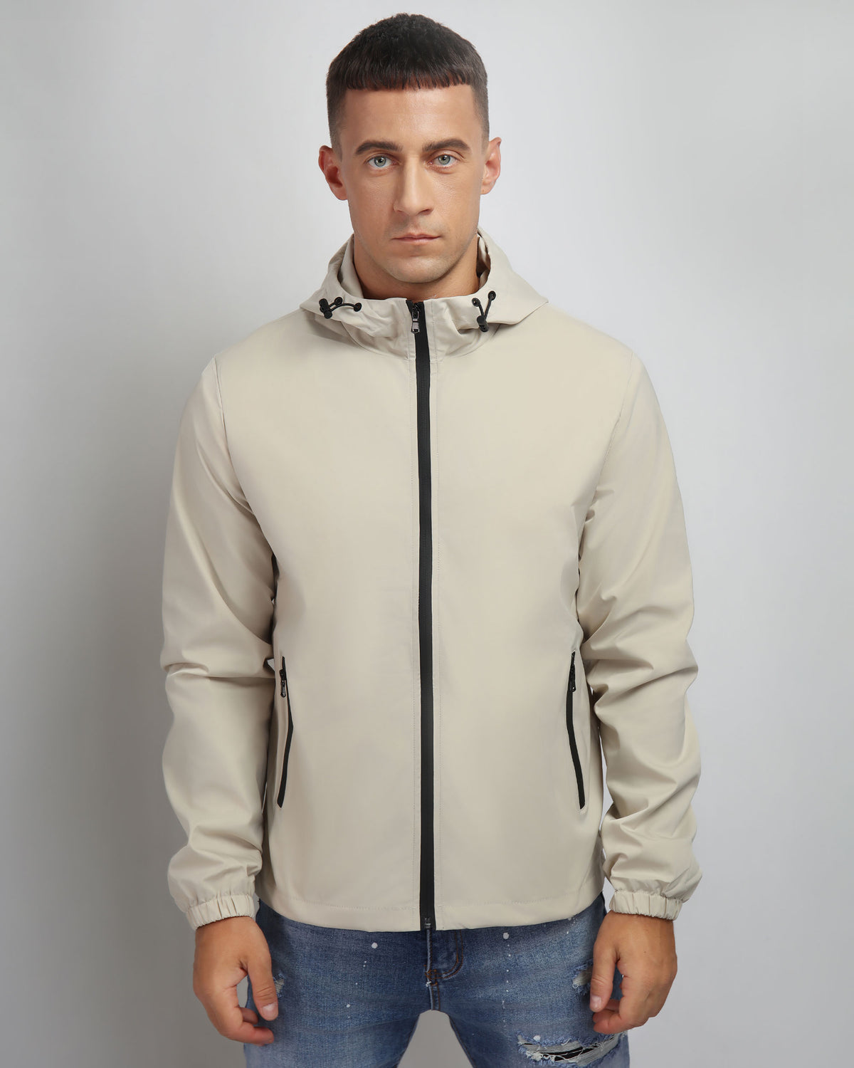 A man wearing a LOGEQI khaki windproof and rainproof jacket with jeans