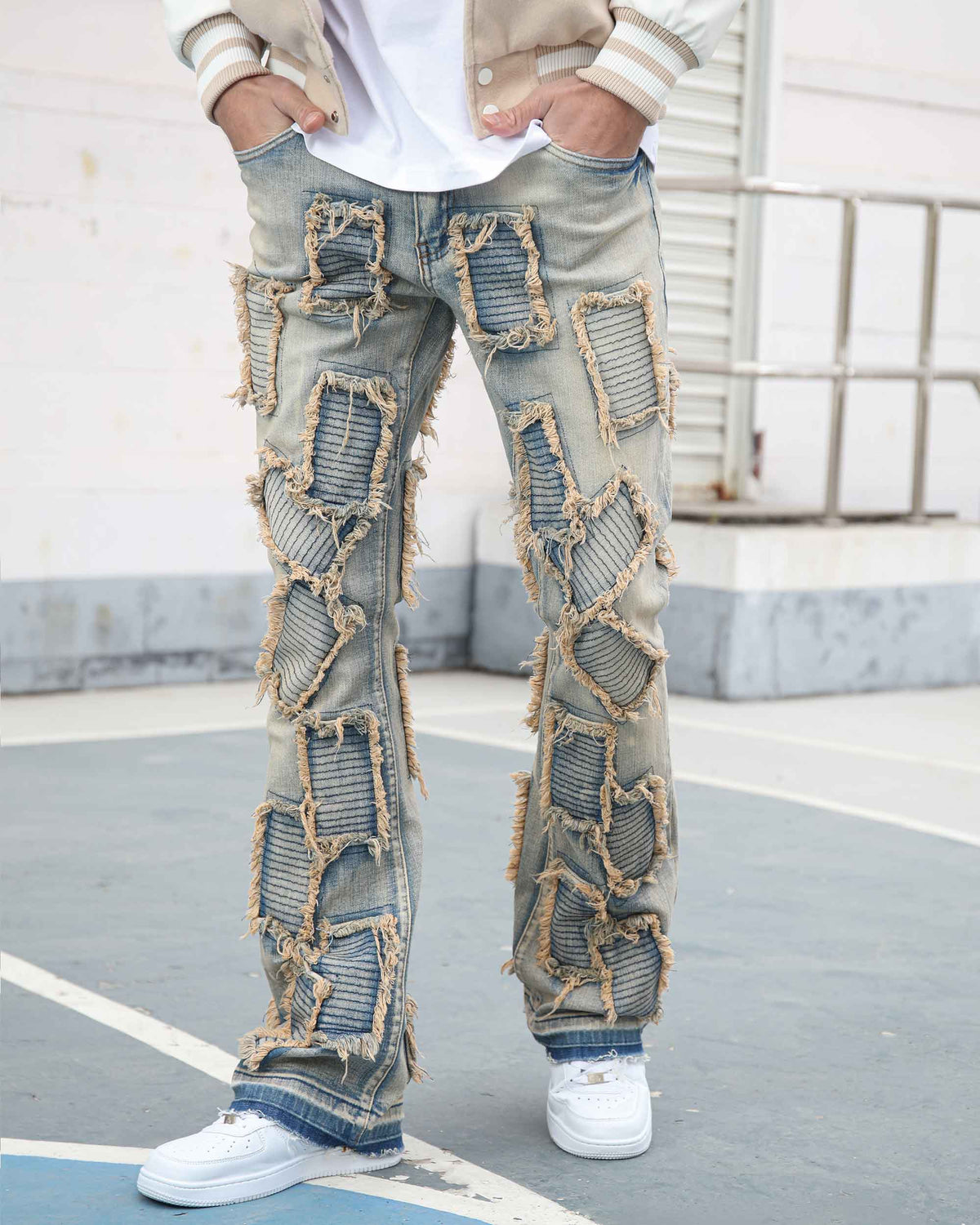 LOGEQI men’s vintage light blue stacked jeans with extreme frayed-edge textured patches all over. Flared and bootcut fit, paired with white sneakers for a bold streetwear look