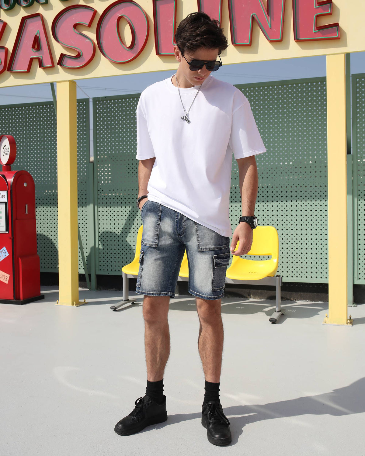 Styling LOGEQI's men's blue denim cargo shorts with distressed details with a white t-shirt, black shoes, sunglasses, and a chain link pendant necklace, creating a streetwear and chic look