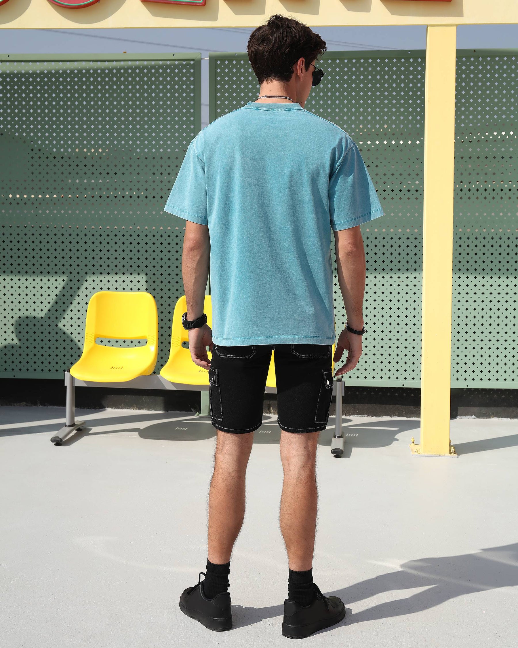 Showing the backside of LOGEQI's black men's denim cargo-style jean shorts