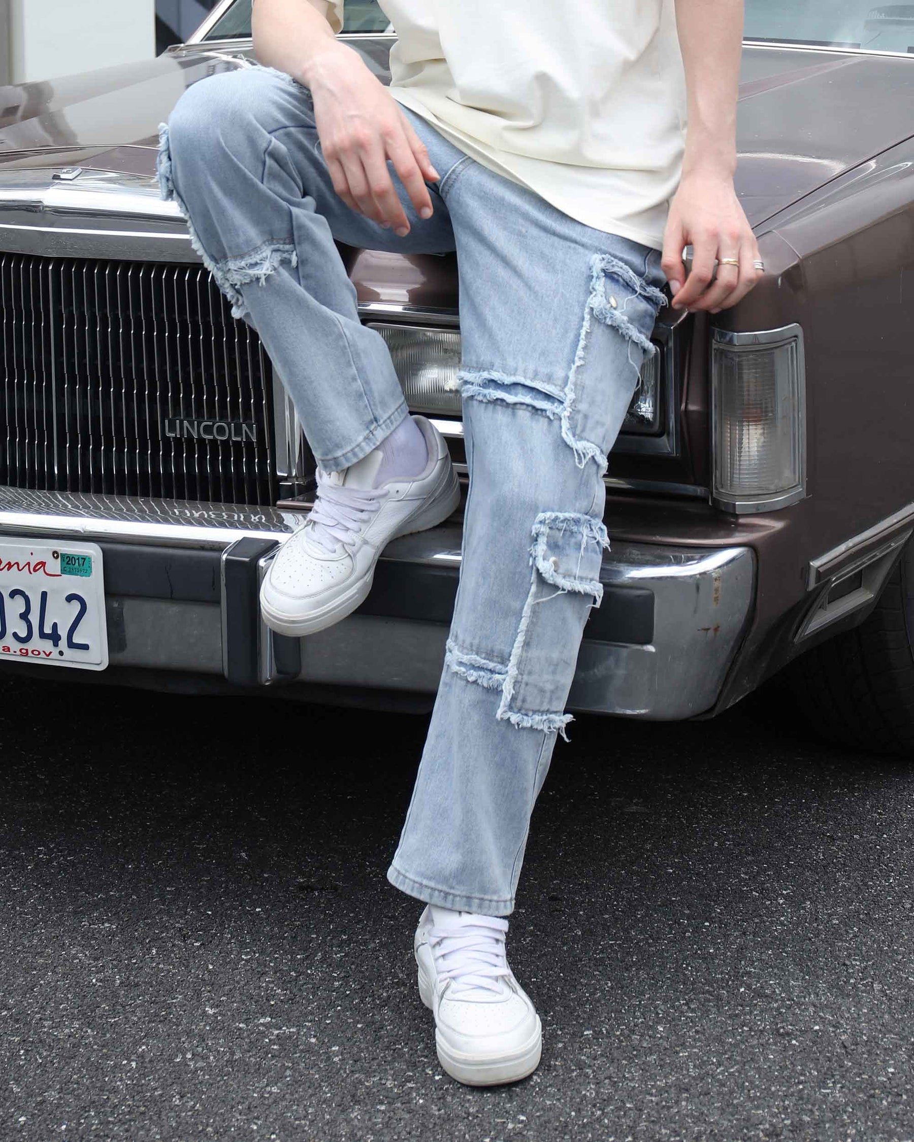 shot-on details of LOGEQI's street-style fringed-edge blue ripped distressed jeans with fringes.