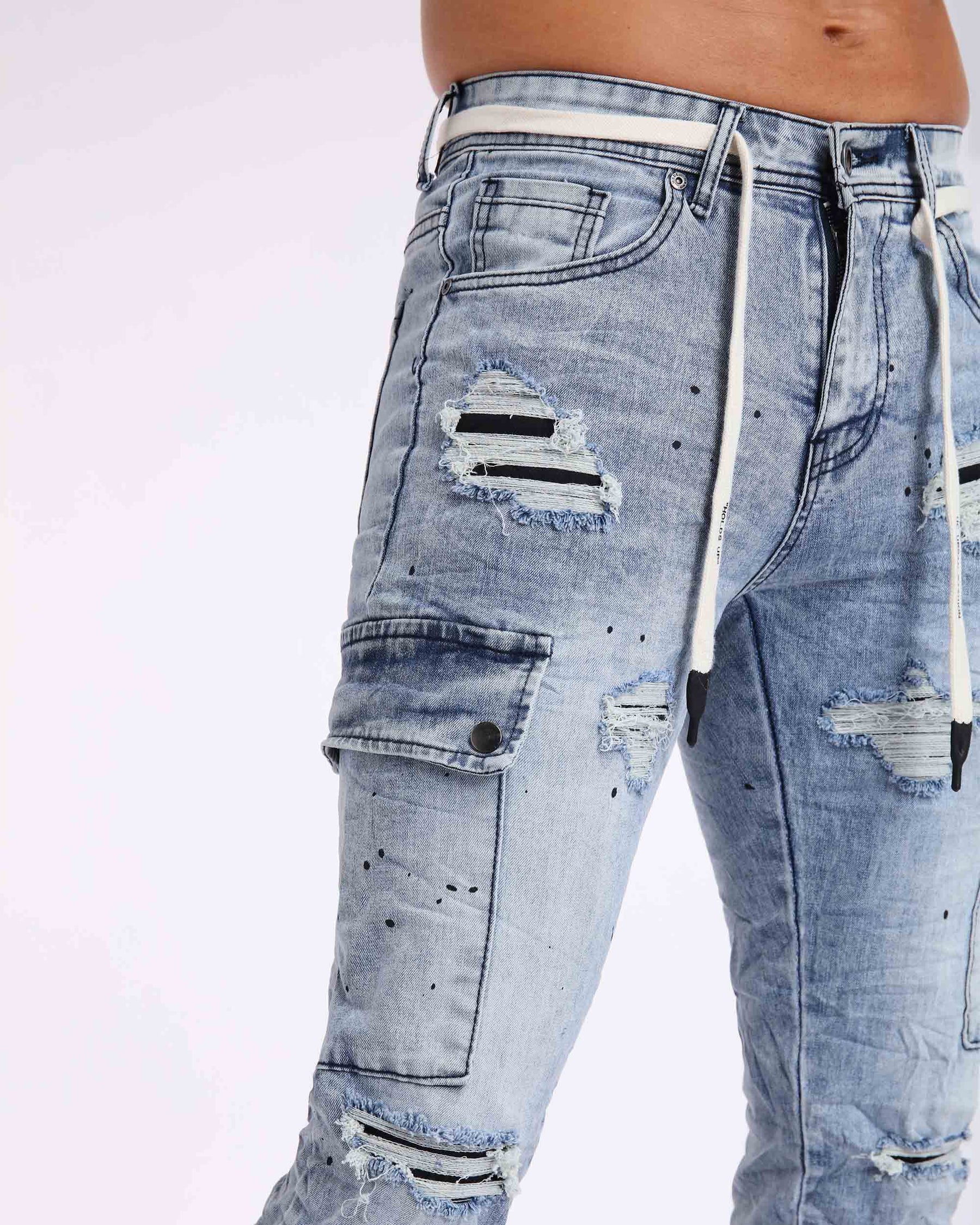 Close-up of LOGEQI's men's light-wash distressed ripped jeans with cargo pockets and black patches under the rips