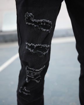 Vaqueros slim desgastados con letras de graffiti negros