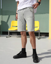 A man wearing LOGEQI's light blue vintage denim shorts on the street.