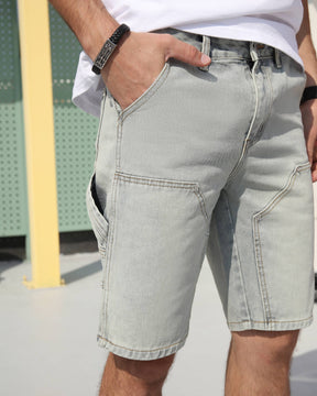 Showing the front pocket details of LOGEQI's light blue vintage-style denim cargo shorts