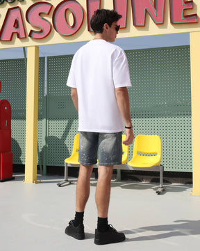 Showing the backside of LOGEQI's denim cargo shorts with white paint spots