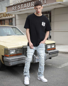A man wearing LOGEQI's light blue layered and ripped baggy jeans with a black T-shirt
