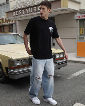Wearing LOGEQI's blue baggy ripped jeans with a loose black T-shirt, creating a casual and stylish look.