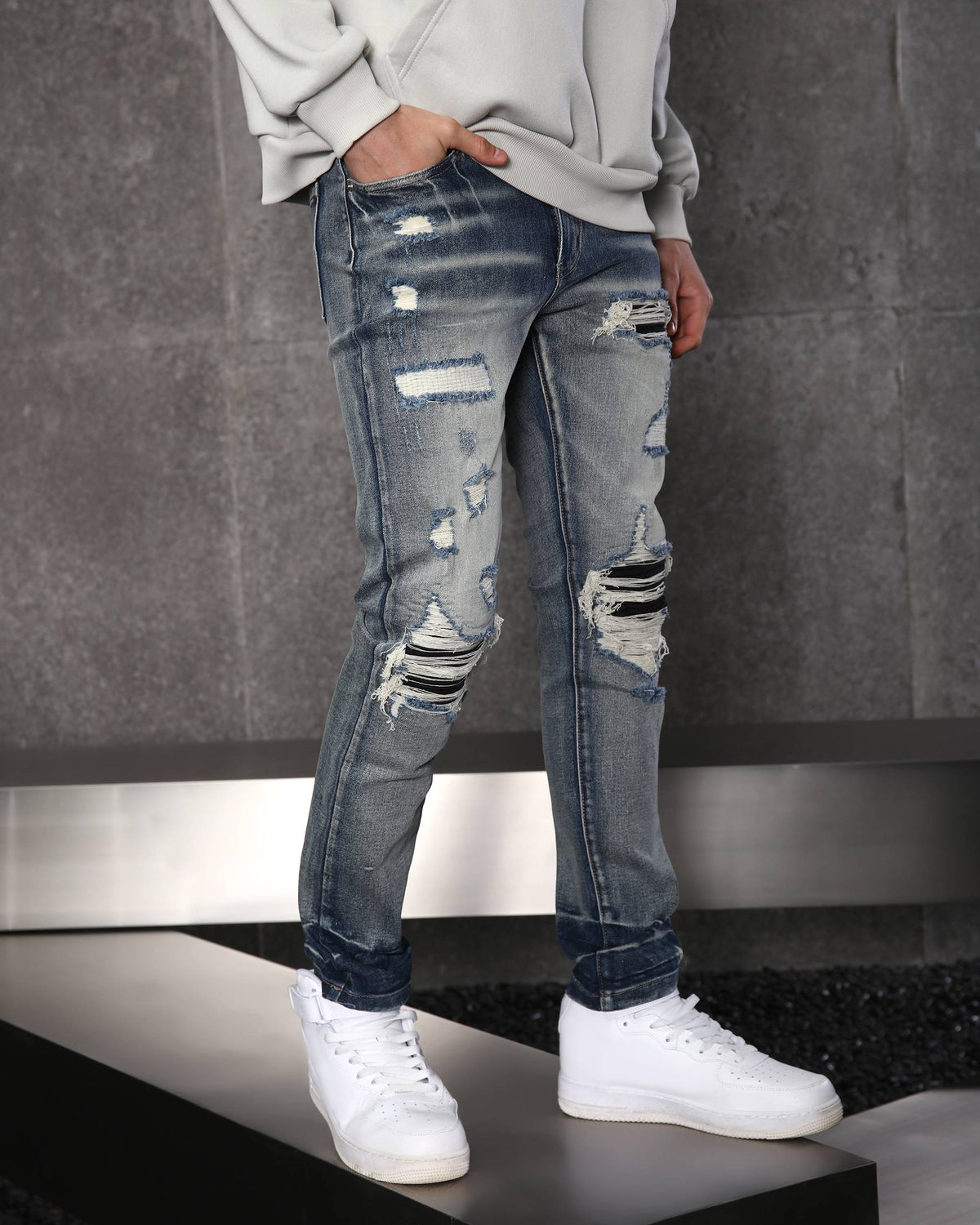 Vaqueros desgastados y rotos azules con parches negros para hombre