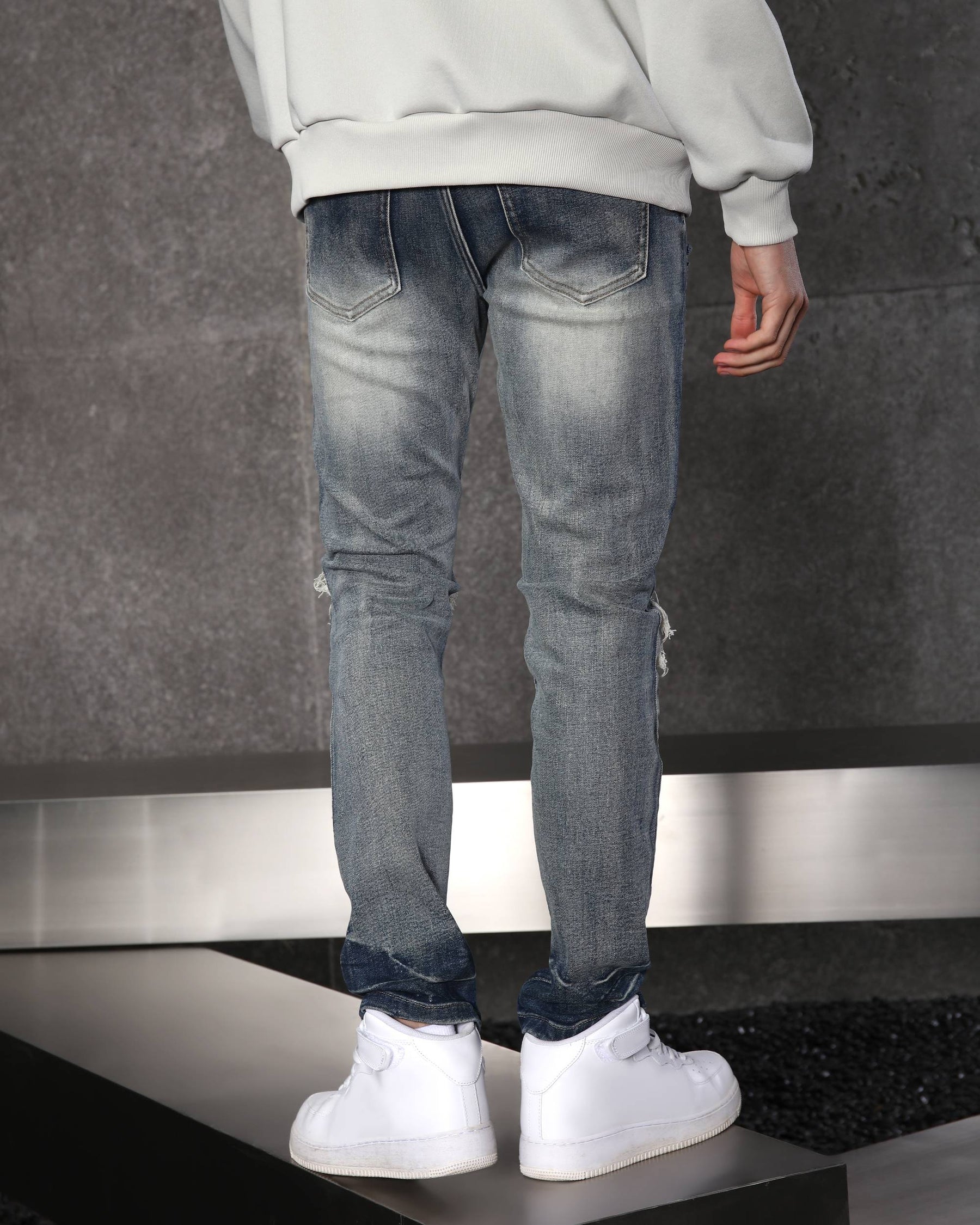 Vaqueros desgastados y rotos azules con parches negros para hombre