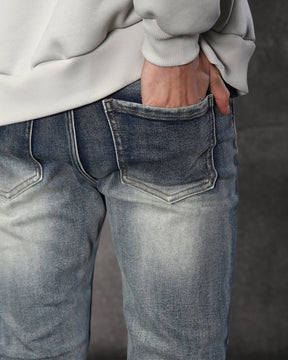 Vaqueros desgastados y rotos azules con parches negros para hombre